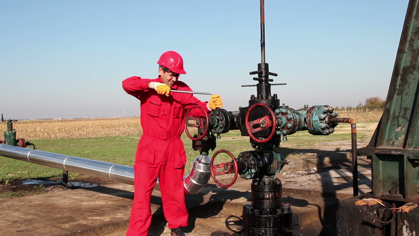 worker verifies oil system outside a plant